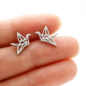 Minimalist silver origami crane earrings shown on fingertip for size scale reference