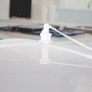 Detail view of the durable drawstring hub and fine mesh top on the folding food cover