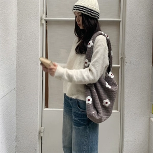 Brown floral knit tote bag styled with white sweater and vintage wide-leg denim pants