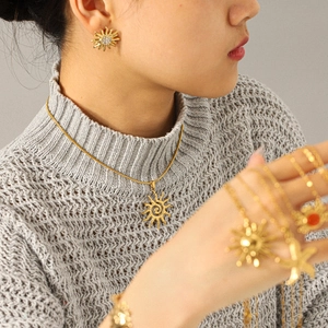 Mannequin portant un ensemble collier pendentif soleil et boucles d'oreilles en or 18k
