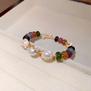 Close-up of Baroque pearl bangle with colorful natural stones and golden wire wrap