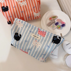 Détail de trousses à maquillage en toile avec imprimé chat rayé et fermeture éclair