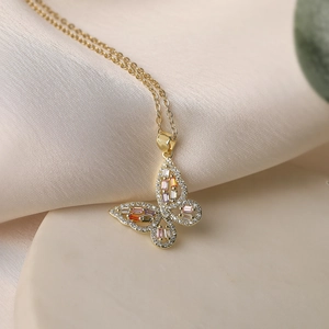 Macro view of 18K gold plated necklace featuring butterfly pendant with colored zircons