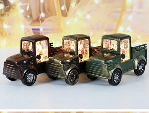Three vintage Christmas truck lanterns with LED lights and Santa Claus in warm bokeh background