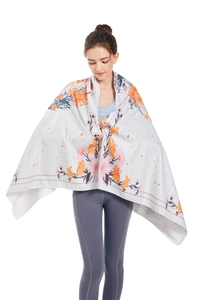 Detail view of large microfiber beach towel featuring vibrant orange floral prints and soft texture