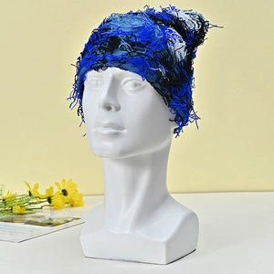 Close-up of winter knit hat with blue mixed colors and unique fringe texture detail