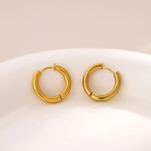 Minimalist 18K gold-plated stainless steel hoop earrings in a white ceramic bowl