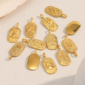 Macro shot of 18K gold plated stainless steel zodiac pendants with crystals on a textured base