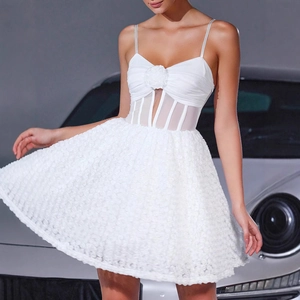 Detail of white mini dress featuring 3D floral corsage and sheer boned bodice structure
