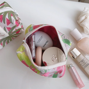 Detail view of pink floral canvas makeup bags with zip closure and magenta lining