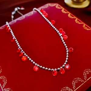 Détail d'un collier pendentif en rubis avec chaîne à billes argentée et boîte à bijoux