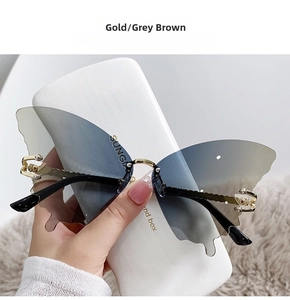 Detail of butterfly shaped sunglasses with gradient lenses and engraved golden metal arms