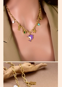 Detail of gold nautical necklace with dolphin, starfish, turquoise, and pearl charms