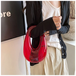 Close-up of red acrylic evening bag with metal chain strap and jelly texture details