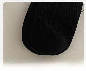 Detailed macro view of black knit socks featuring reinforced toes and cable knit texture