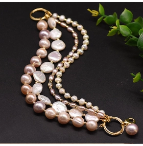 Macro view of multi-layer baroque pearl bracelet with pink and white tones and gold clasp