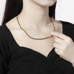 Minimalist gold flat snake chain necklace made of stainless steel worn by model