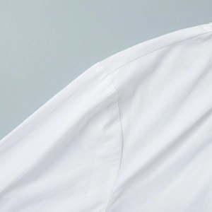 Detailed close-up of shoulder stitching and sleeve seam on a white stand-collar shirt