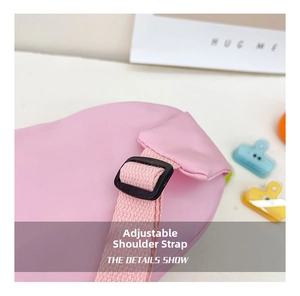 Detailed close-up of adjustable pink fabric shoulder strap with black buckle for kids bag