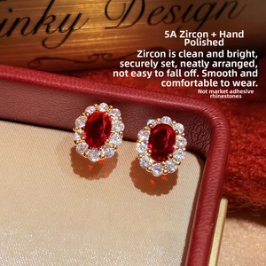 Macro shot of 18K gold plated oval earrings with red ruby zircon and 5A crystal halo