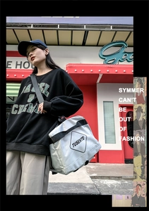Close-up of a large grey oxford street-style crossbody bag with TUSENTE logo print