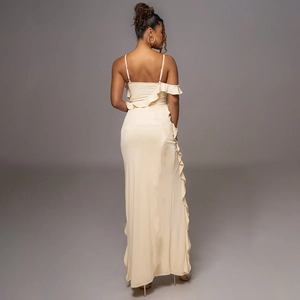 Detail of elegant backless cream maxi dress with delicate straps and ruffled side slit