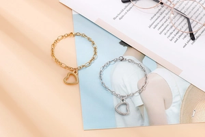 Detailed comparison of gold and silver hollow heart pendants with twisted rope texture