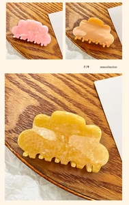 Detailed view of colorful cloud-shaped acrylic hair claws with elegant marble texture