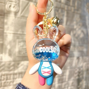Close-up of cute acrylic liquid rabbit keychain with blue glitter stars and gold bell