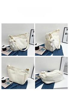 Minimalist cream canvas tote bag detail view with side pocket and plush bear pendant