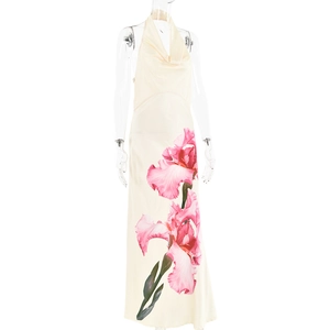 Détail de la robe longue dos nu avec imprimé floral rose sur un tissu beige lisse
