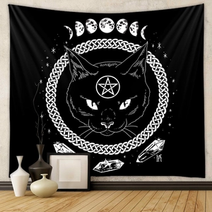 Detail of black cat tapestry with moon phases and celtic knots on a beige wall