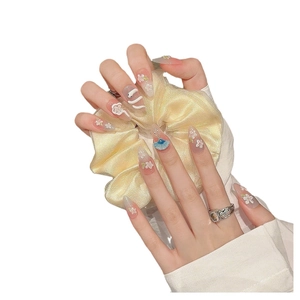 Pink gradient press-on nails with 3D floral reliefs and blue accents on almond shape