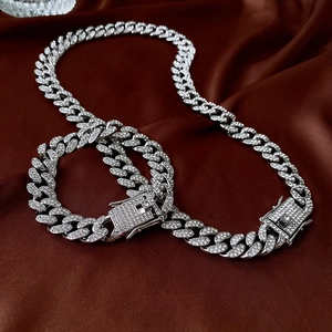 Detailed view of silver Cuban link necklace and bracelet set with iced-out rhinestones