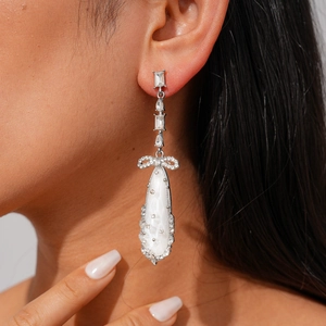 Boucles d'oreilles élégantes avec nœud et goutte d'eau en zircon sur modèle féminin