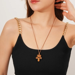 Close-up of a tiger eye stone flower pendant on a wax cord worn by a model