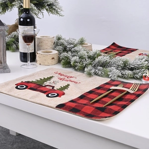 Linen Christmas placemat with red black plaid and embroidered truck on white table