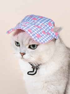 Dettaglio del cappellino per cani a quadri blu con stampa di fragole e cinturino regolabile