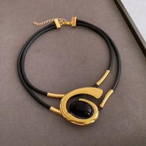 Detail of vintage oval black stone pendant on golden spiral double-layer cord necklace