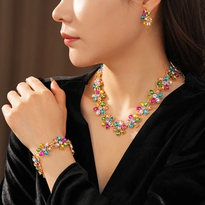 Close-up of vintage gold flower jewelry set with colorful gemstones on a model
