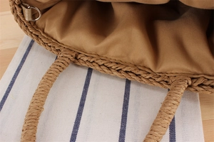 Detailed macro view of beige fabric lining and handwoven handle on straw beach bag