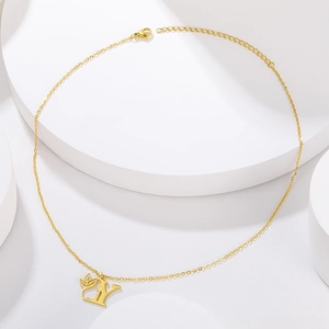 Detail of gold necklace featuring letter Y pendant and leaf charm on white podium