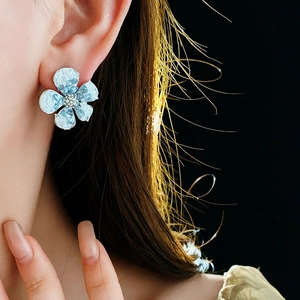Close-up of blue gradient crystal flower earrings worn with elegant side profile view