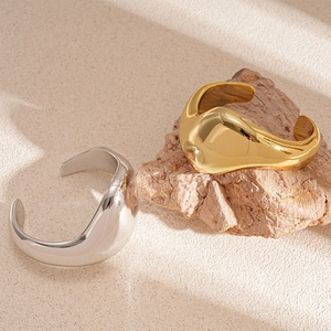 Minimalistische unregelmäßige Armreifen aus Metall in Gold und Silber glänzend