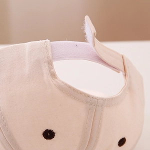 Macro detail of infant baseball cap featuring adjustable hook and loop strap and embroidery