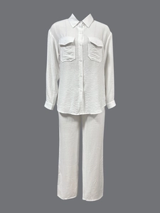 Detail of white cotton linen two-piece set showing fabric texture and chest pockets