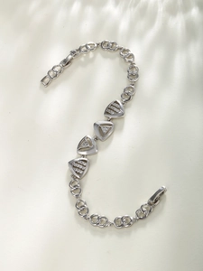 Detail view of silver geometric triangle bracelet with sparkling zircon stones in a macro shot