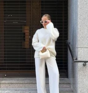 Détail du pull blanc en mohair associé à un pantalon large pour un look épuré