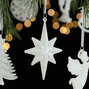 Sparkling white Christmas hanging ornaments with glitter stars and trees on dark background
