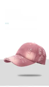 Close-up of distressed edges and ripped details on pink vintage washed cotton baseball cap